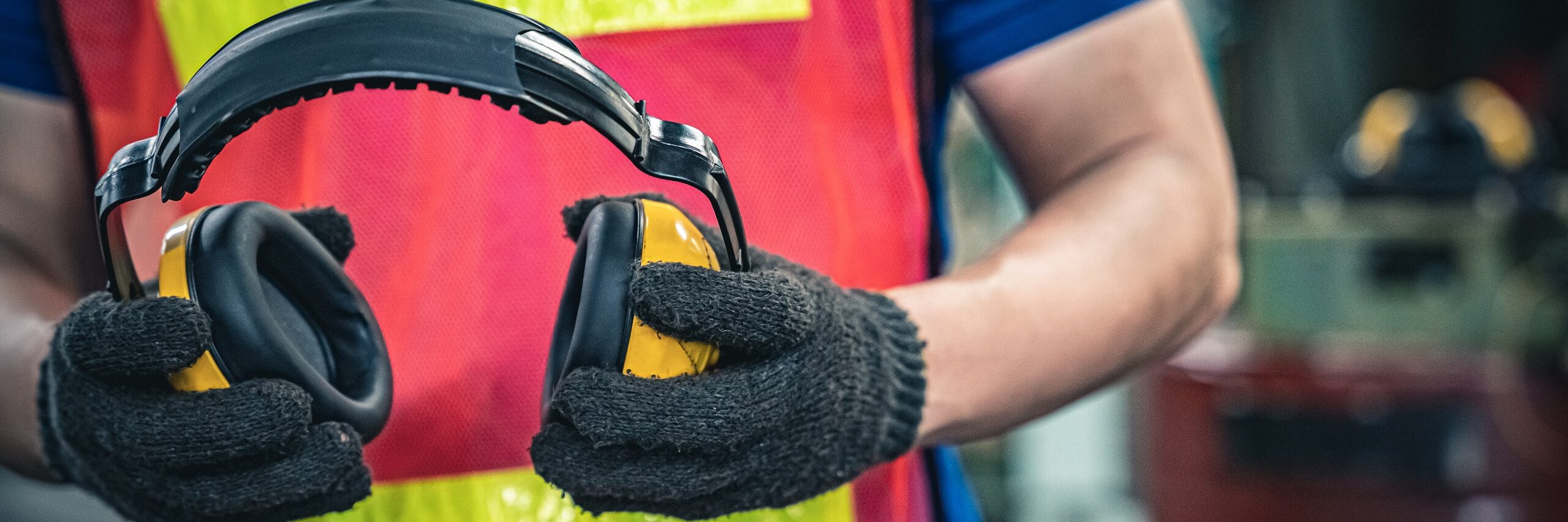Man holds ear protection demonstrating one of many Environmental Health and Safety aspects covered by Thrive Talent